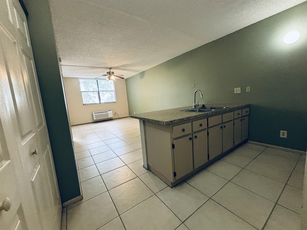 2401 Riverside Drive, Unit 311B Coral Springs, FL 33065 - Photo 6 of 12 a kitchen with stainless steel appliances a sink and cabinets