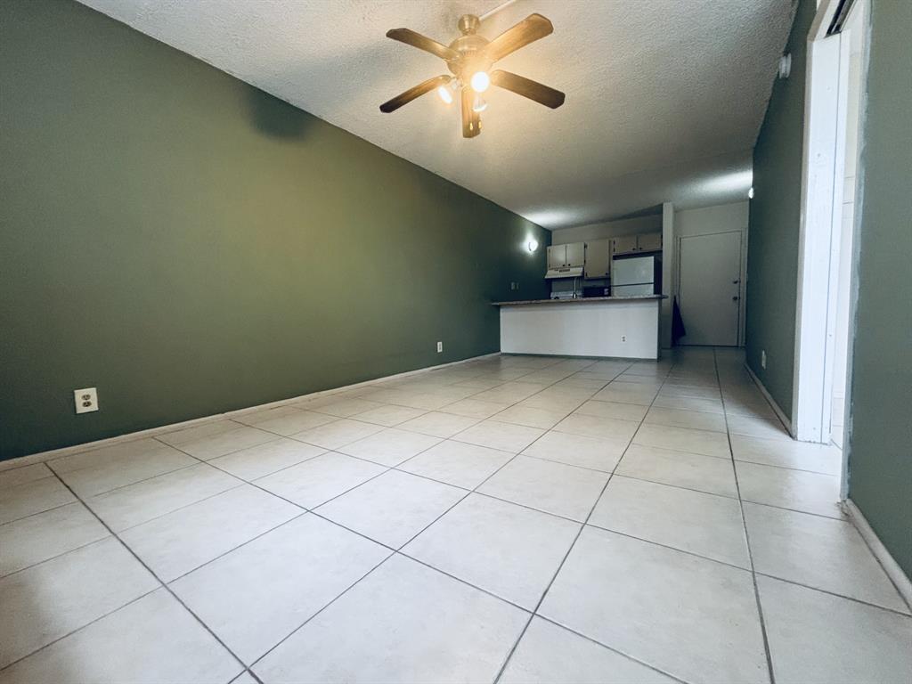2401 Riverside Drive, Unit 311B Coral Springs, FL 33065 - Photo 9 of 12 a room with a chandelier fan and kitchen view