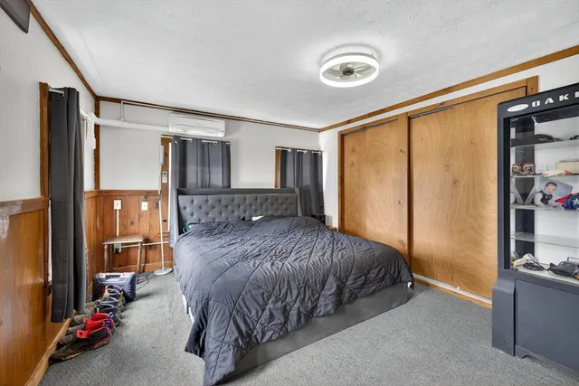 a bedroom with a bed couch and a window