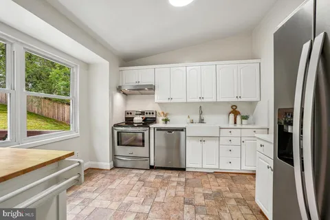 a kitchen with stainless steel appliances a stove a sink and a refrigerator