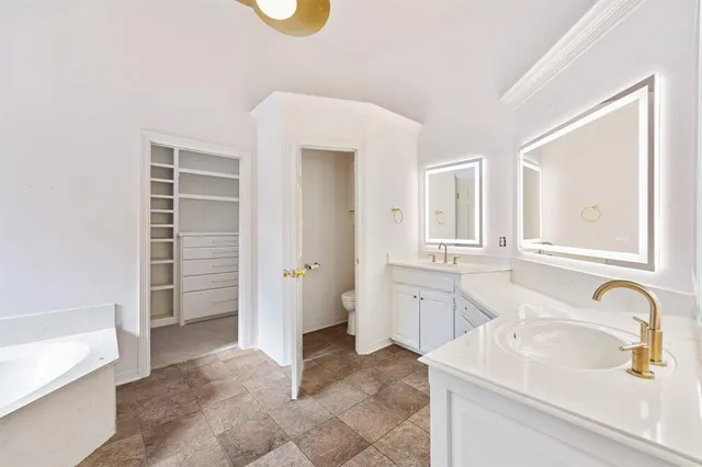 a bathroom with a sink a bathtub and a double vanity sink