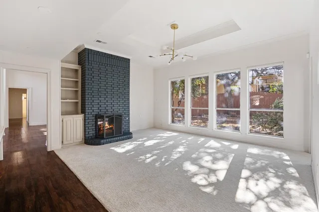 a view of an empty room with a fireplace and a window