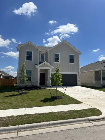 a view of a house with a yard and garage