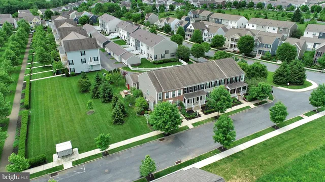 an aerial view of residential house with outdoor space and trees all around