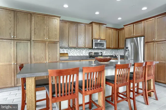 a kitchen with stainless steel appliances granite countertop a stove a sink and a refrigerator