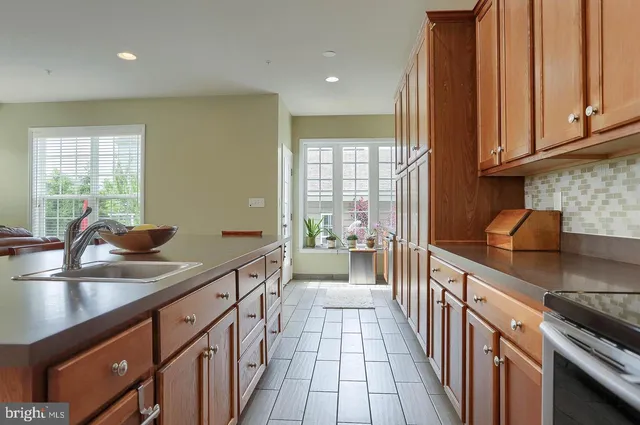 a kitchen with stainless steel appliances granite countertop a sink stove and cabinets