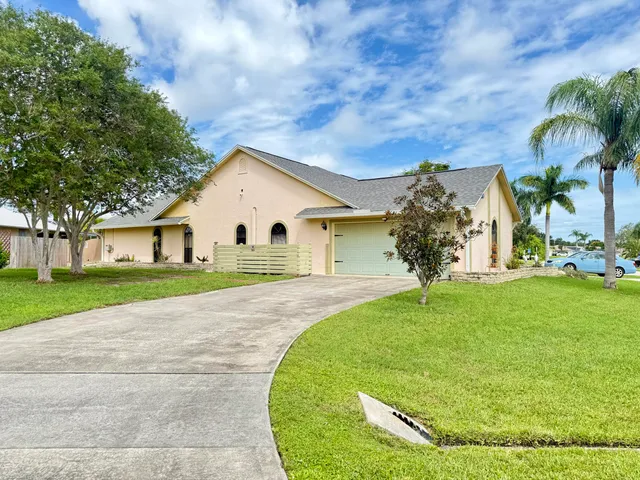 a view of a white house with a yard
