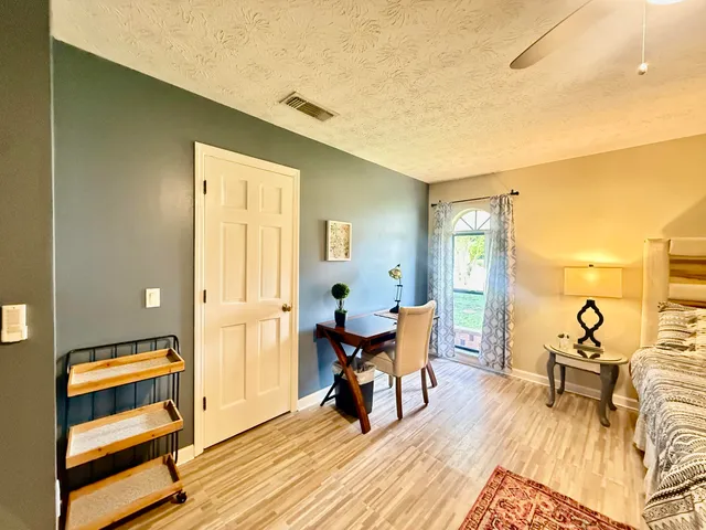 a spacious bedroom with a bed and wooden floor