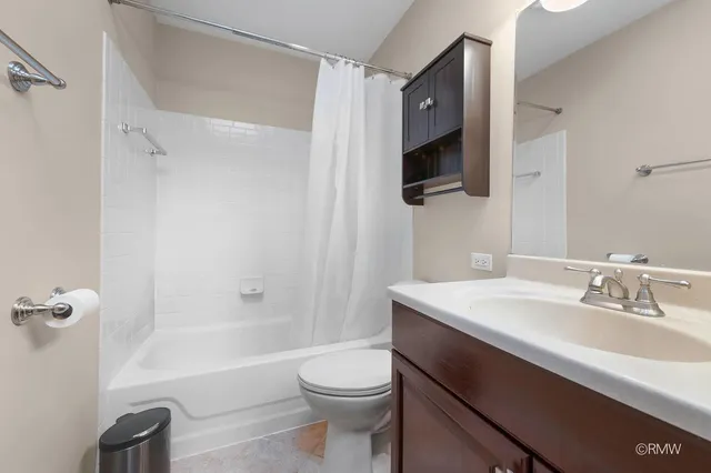 a bathroom with a sink a toilet a mirror and shower