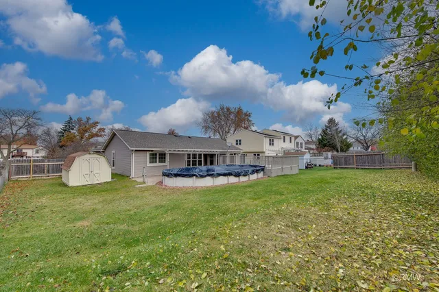 a view of a house with a big yard and large trees
