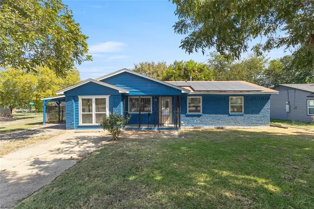 a front view of a house with a garden and patio