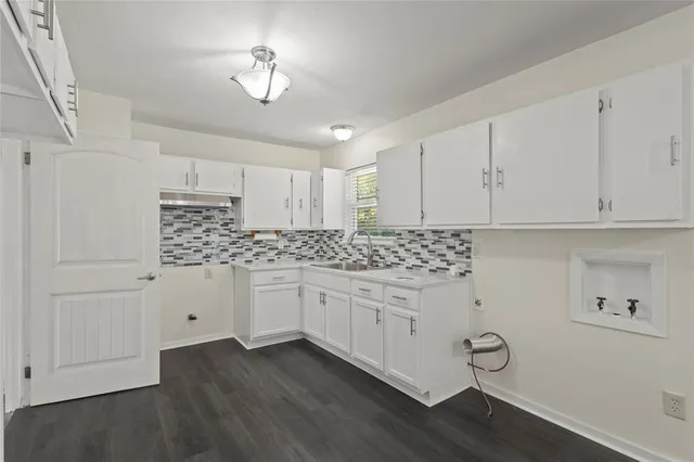a kitchen with granite countertop white cabinets and white appliances