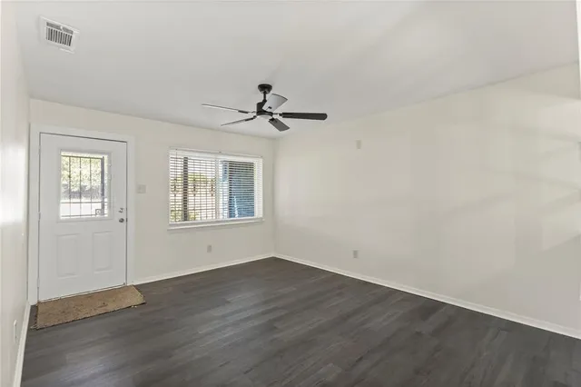 a view of a room with wooden floor and windows