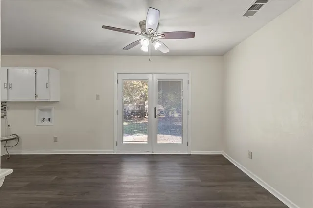 a view of wooden floor and a chandelier fan in a room