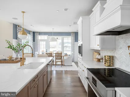 a large kitchen with stainless steel appliances a sink a counter space and a window