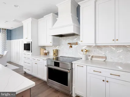a kitchen with stainless steel appliances white cabinets and a sink