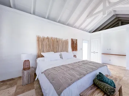 a large bed sitting in a bedroom next to a larger window