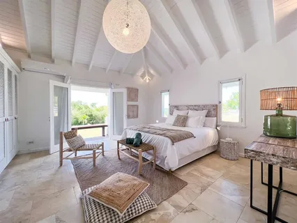 a spacious bedroom with a bed a table and chair