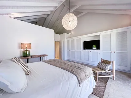 a spacious bedroom with a bed and a flat screen tv