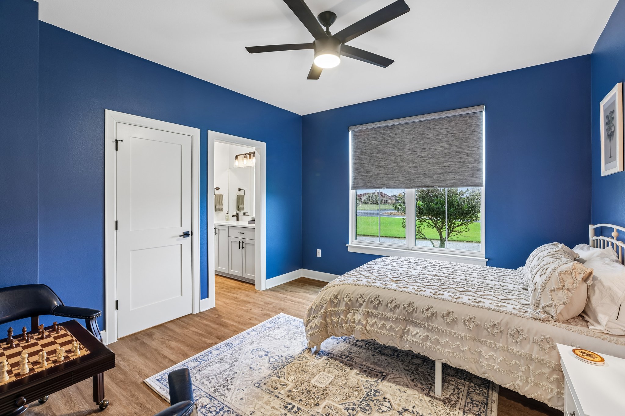 113 Crystal Lane Georgetown, TX 78633 - Photo 25 of 32 Bright bedroom with a ceiling fan, durable vinyl plank flooring, and a view of the outside through the large window.