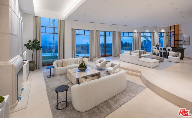 a living room with furniture potted plant and glass door