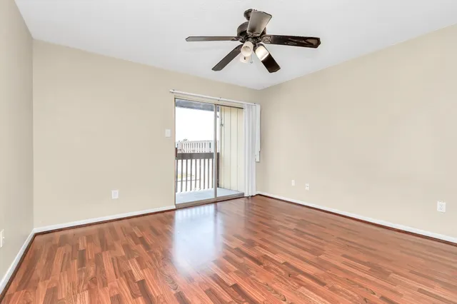 a view of room with hardwood floor and ceiling fan