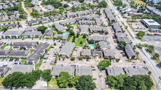 an aerial view of a city with lots of residential buildings ocean and mountain view in back