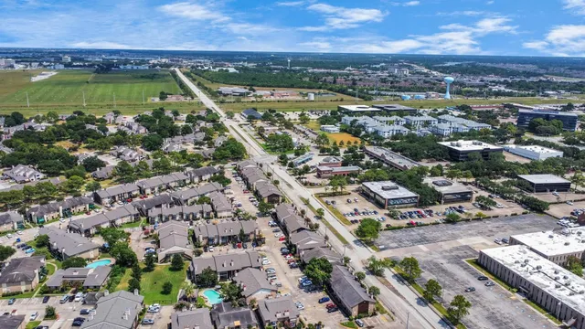 an aerial view of ocean and residential houses with outdoor space