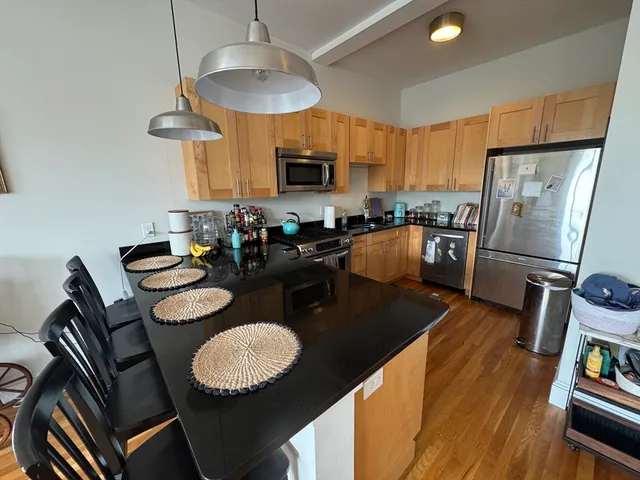 a kitchen with sink refrigerator dining table and chairs