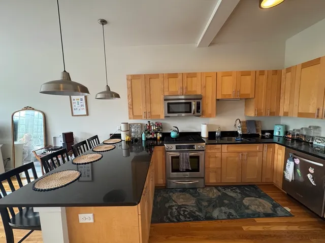 a kitchen with stainless steel appliances granite countertop a sink a stove top oven a counter space and cabinets