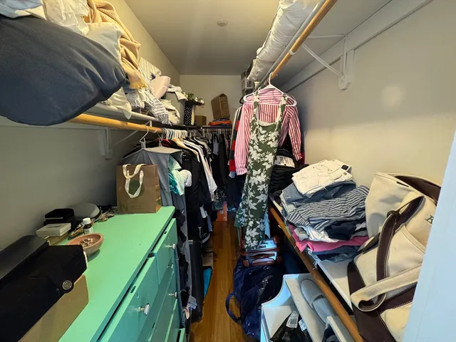a view of walk in closet with clothes and shoes