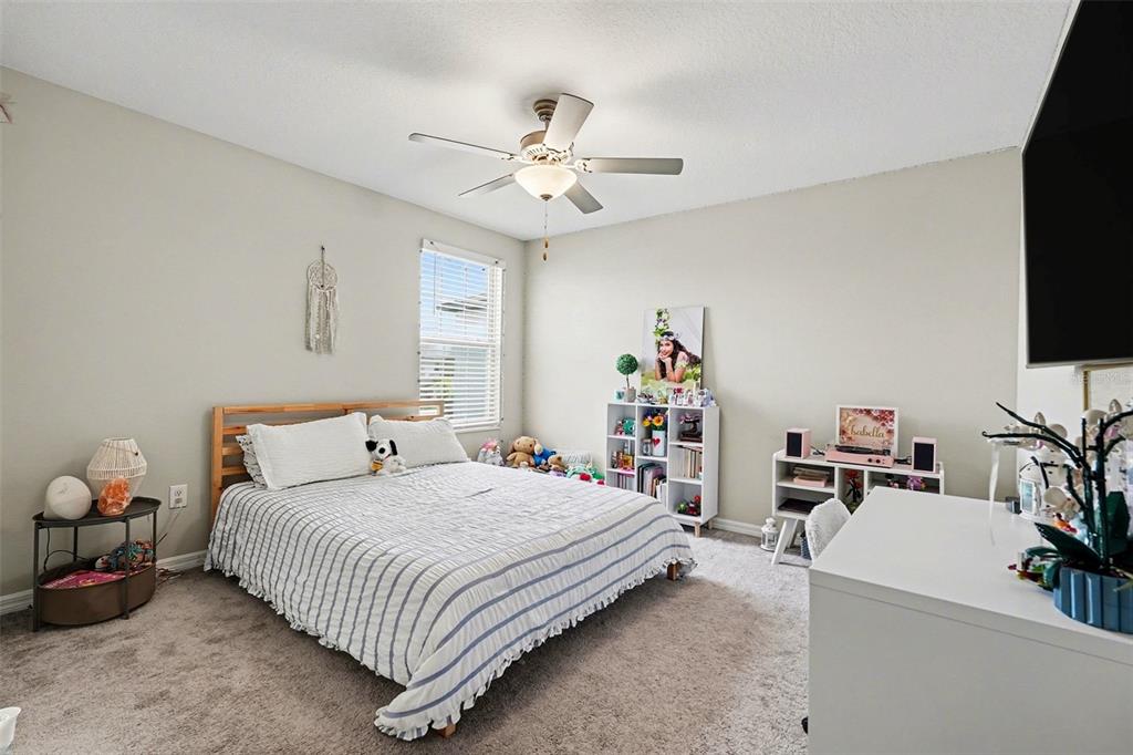9424 Lemon Drop Loop Sun City Center, FL 33573 - Photo 21 of 31 a bedroom with a bed and a flat screen tv
