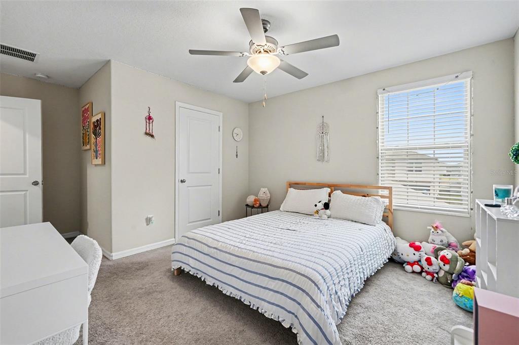 9424 Lemon Drop Loop Sun City Center, FL 33573 - Photo 22 of 31 a bedroom with a bed and a chandelier