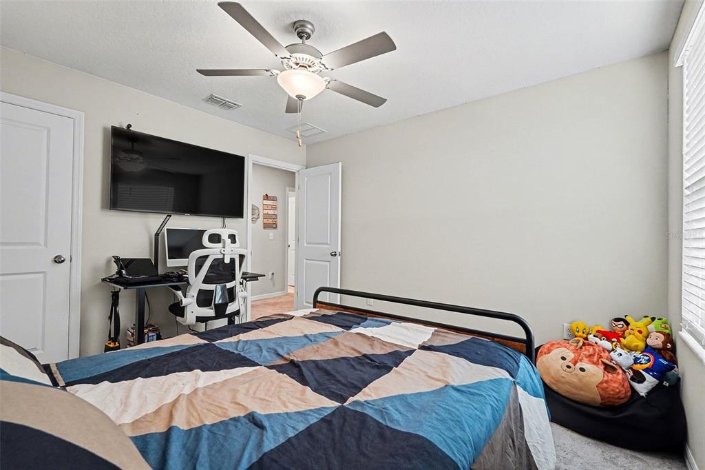 9424 Lemon Drop Loop Sun City Center, FL 33573 - Photo 26 of 31 a bedroom with a bed and a flat screen tv
