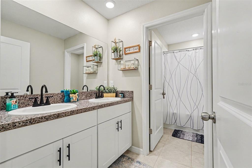 9424 Lemon Drop Loop Sun City Center, FL 33573 - Photo 27 of 31 a bathroom with a double vanity sink and a mirror
