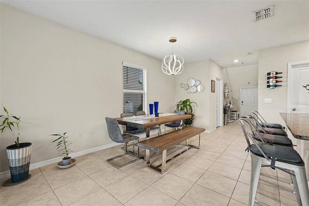 9424 Lemon Drop Loop Sun City Center, FL 33573 - Photo 7 of 31 a living room with furniture and a dining table with potted plants