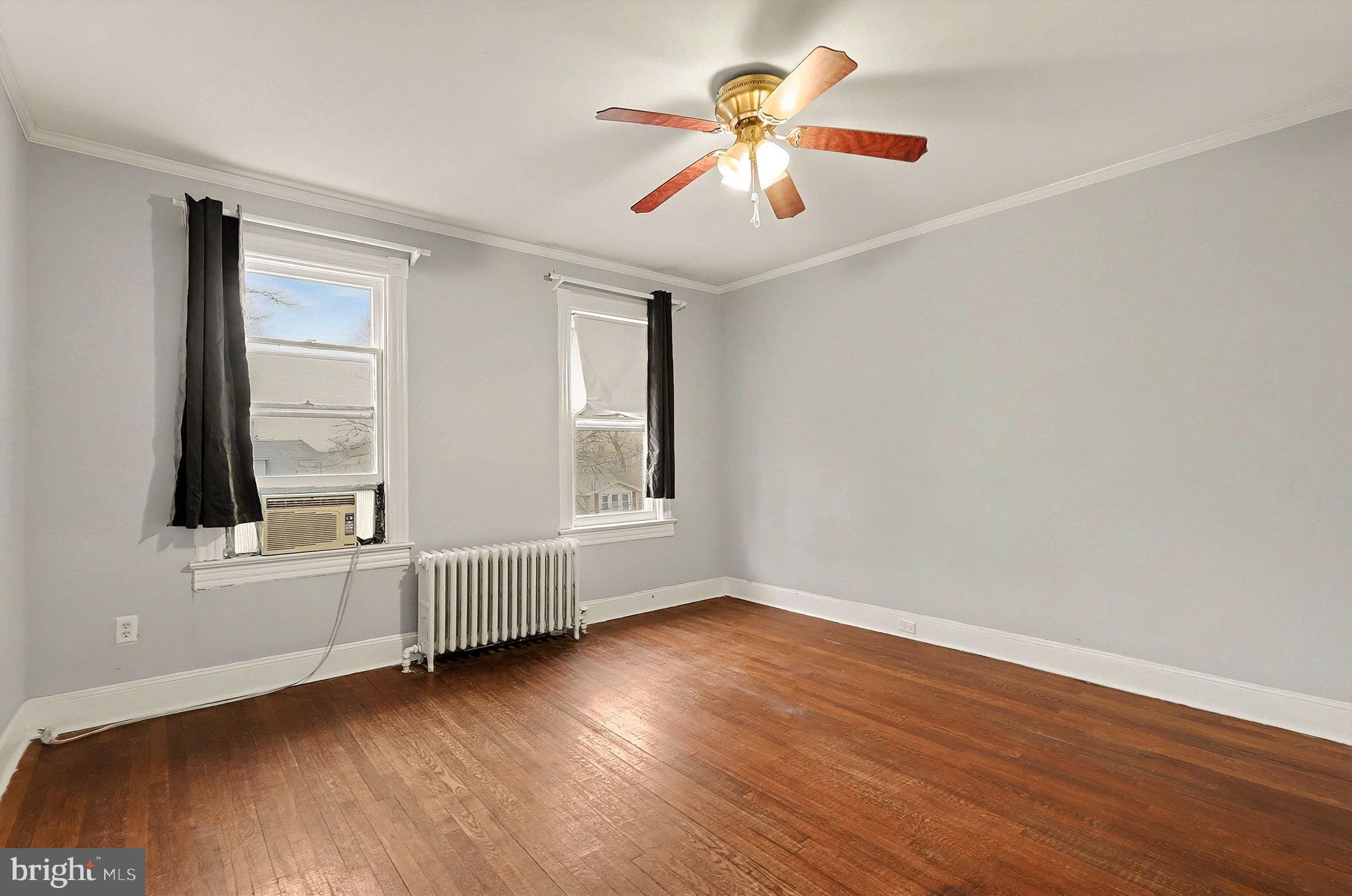 4014 33rd Street Mount Rainier, MD 20712 - Photo 22 of 37 an empty room with wooden floor chandelier fan and windows