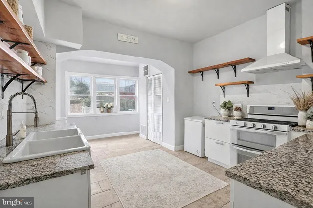 an empty room with wooden floor chandelier fan and windows