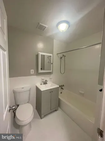 a bathroom with a toilet sink vanity tub and mirror
