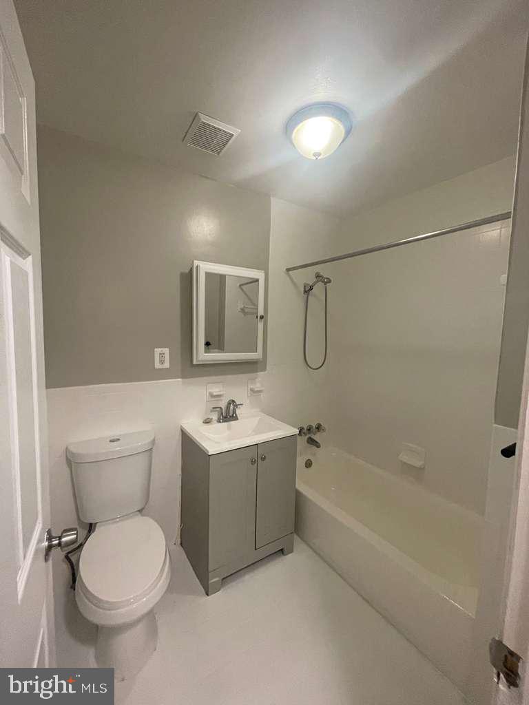 2830 R Street Southeast Washington, DC 20020 - Photo 14 of 14 a bathroom with a toilet sink vanity tub and mirror