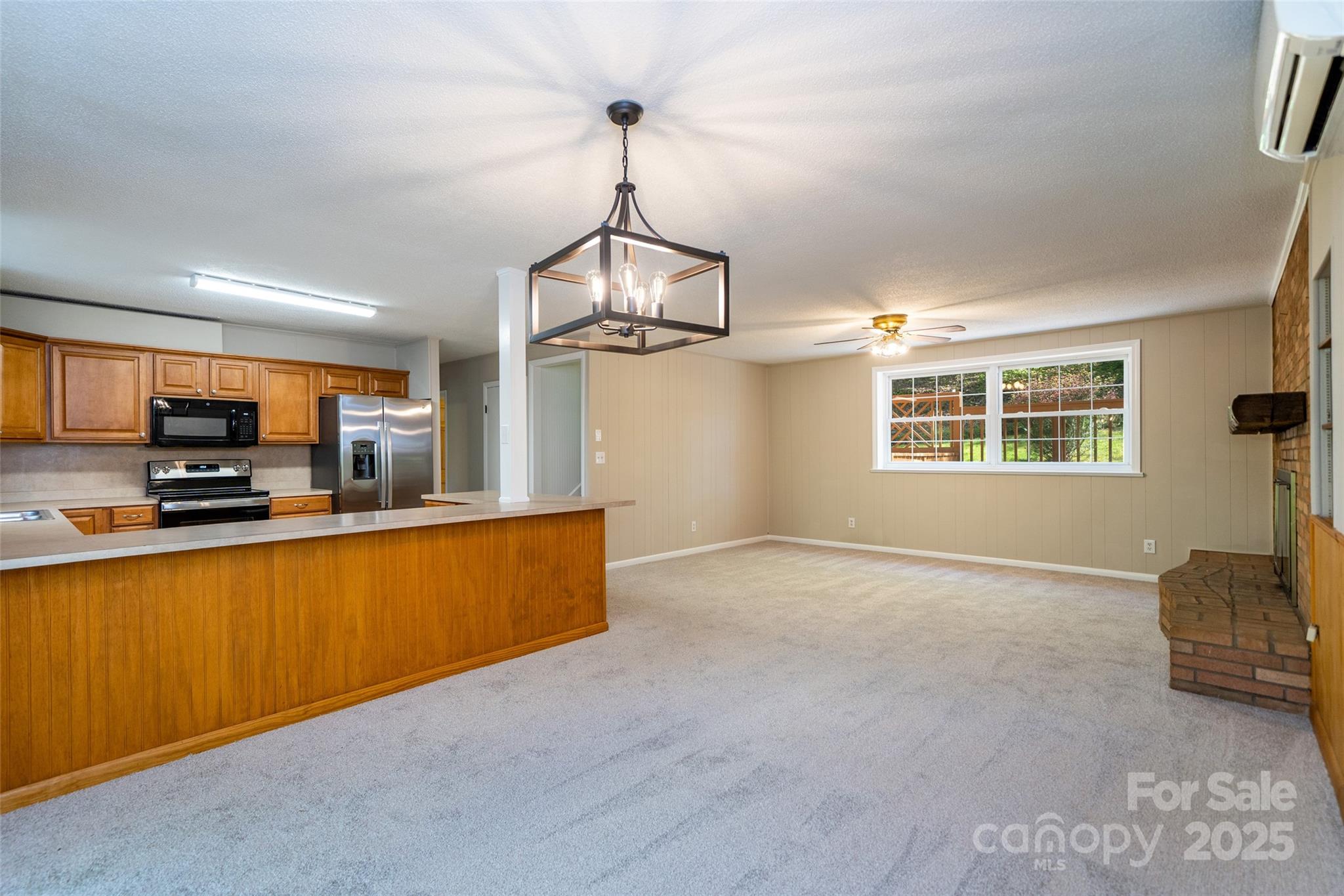145 Jeter Mountain Road Hendersonville, NC 28739 - Photo 9 of 31 a view of a kitchen with kitchen island a sink wooden floor and living room view