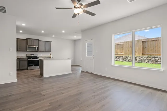 a view of kitchen with kitchen island wooden floor and stainless steel appliances
