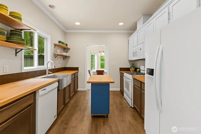a kitchen with a sink stove and wooden floor