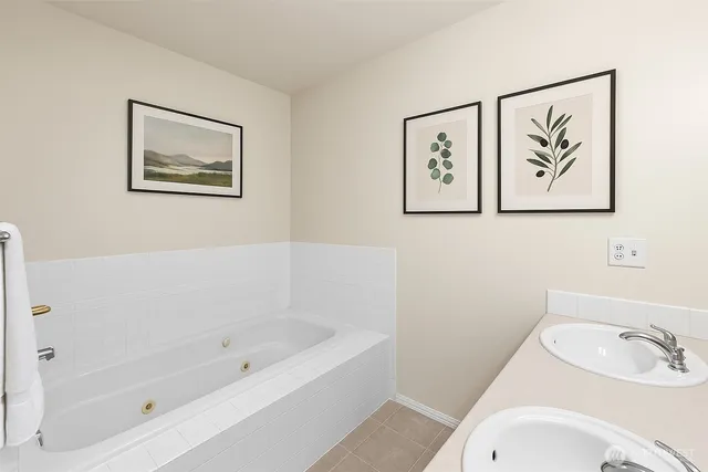 a white bath tub sitting next to a white sink and vanity