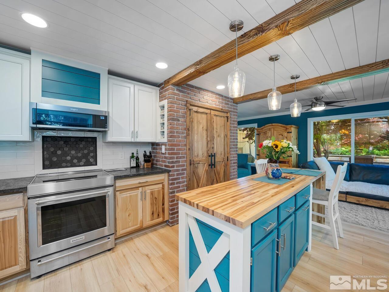 14555 Sundance Drive Reno, NV 89511 - Photo 13 of 40 a kitchen with granite countertop a stove and a wooden floors