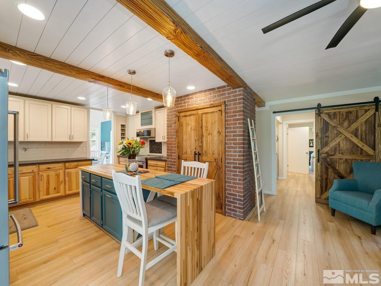 14555 Sundance Drive Reno, NV 89511 - Photo 14 of 40 a kitchen with a table chairs wooden floors and a view of living room