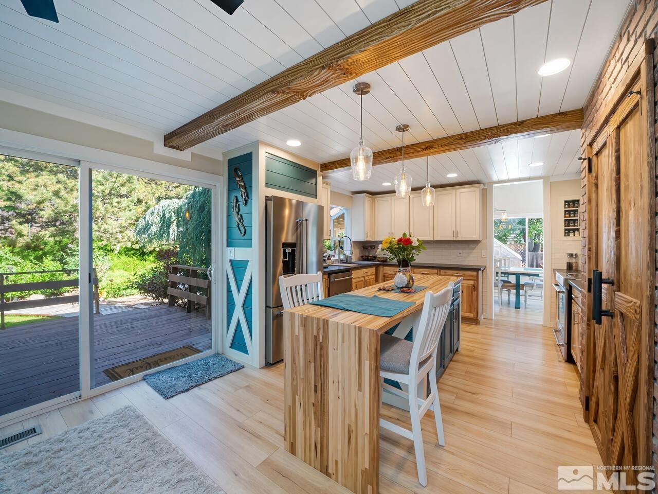 14555 Sundance Drive Reno, NV 89511 - Photo 15 of 40 a dining hall with stainless steel appliances granite countertop a refrigerator a sink dishwasher and a dining table with garden view