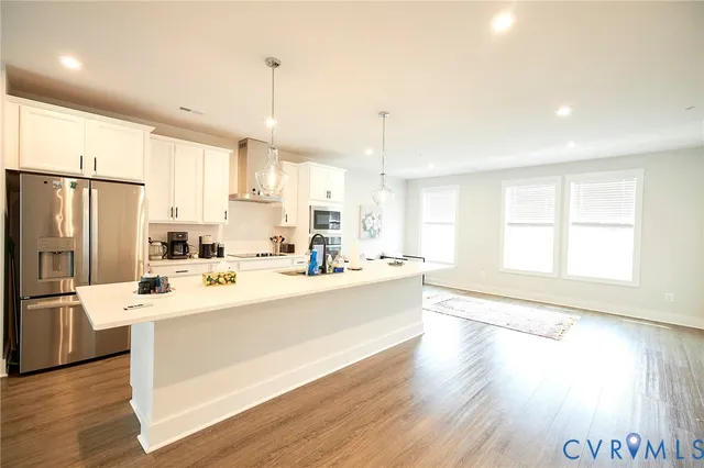 a large kitchen with a window and stainless steel appliances