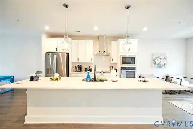 a kitchen with kitchen island a sink and a refrigerator