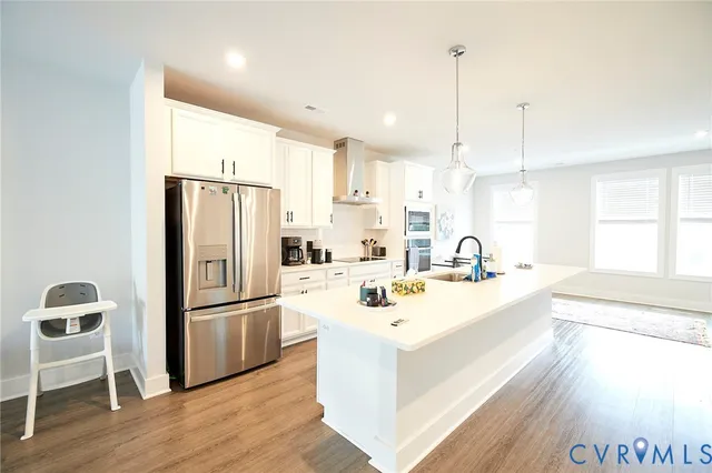 a large white kitchen with a refrigerator a sink and a stove